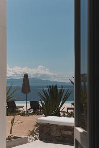 凯勒里瓦迪米科诺斯潘泰恩公寓酒店的海滩景客房 - 带遮阳伞和椅子