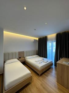 卡萨米尔GL Hotel Ksamil的一间卧室设有两张床和窗户。
