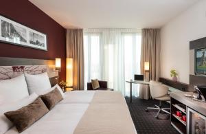 慕尼黑慕尼黑里奥纳多皇家酒店的配有一张床和一张书桌的酒店客房