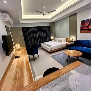 尼甘布Negombo Ocean Breeze Luxury Studio by Serendib Vacation的酒店客房,配有床和蓝色的沙发