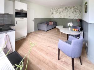 NistelrodeNisterlo Guesthouse的厨房以及带桌椅的起居室。