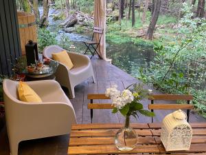 维亚纳堡Wild Glamping Portugal with hot tub to relax in Viana do Castelo的门廊配有椅子和一张带花瓶的桌子