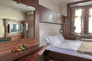 贝尔格莱德维拉特雷兹吉酒店的一间卧室配有一张带镜子的床和一张书桌