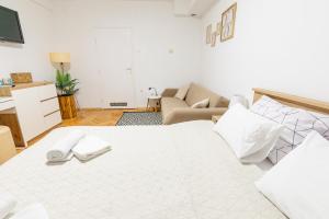 查科韦茨Apartman Lumi的卧室配有一张白色的大床和一张沙发。