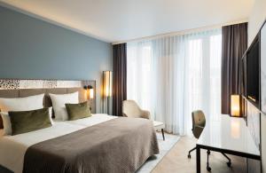 慕尼黑慕尼黑里奥纳多皇家酒店的配有一张床和一张书桌的酒店客房