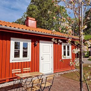 南雪平Korskullens Stugor的前面设有一张桌子和椅子的红色小屋