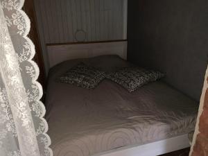 Nurme farm的一张带两个枕头和窗帘的床