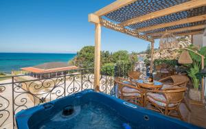 阿凯松Casa di Cuore - Beachfront的阳台设有蓝色浴缸,配有桌椅