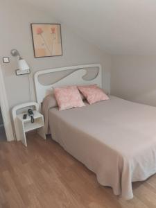 桑提亚纳德玛罗希达罗斯酒店的卧室配有白色床和粉红色枕头