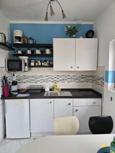 马斯林尼察Apartmani Nata的厨房配有白色橱柜和水槽