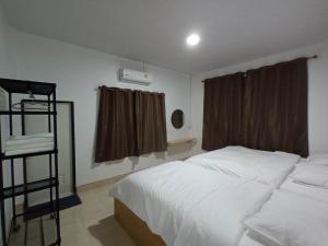 勿洞JW Homestay Betong เจ ดับบลิว โฮมสเตย์ เบตง的卧室配有白色的床和窗户。