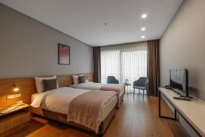 卡兹贝吉Hotel Memoir Kazbegi by DNT Group的配有一张床和一台平面电视的酒店客房
