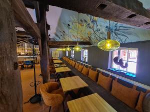 巴德茨维什安Ahrenshof 8的一间带木桌和椅子的餐厅以及壁画