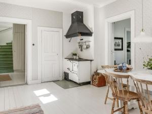 SkinnskattebergHoliday Home Idyllen - VML115 by Interhome的厨房配有炉灶和桌椅