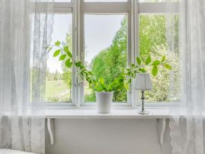 SkinnskattebergHoliday Home Idyllen - VML115 by Interhome的白色窗台上一扇带植物的窗户