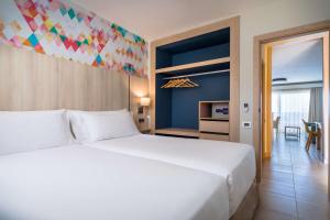 圣地亚哥港阿勒格罗伊索拉酒店的一间带一张白色大床的卧室和一间用餐室