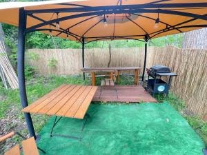 赫尔Your Camp Hel的一张野餐桌和一把伞下的烤架
