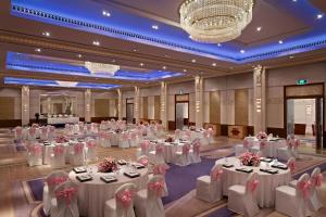 班加罗尔ITC Gardenia, a Luxury Collection Hotel, Bengaluru的一个带白色桌椅的大型宴会厅