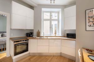 哥本哈根Stylish Flat at Best Location in CPH by The Canals的厨房配有白色橱柜和窗户。