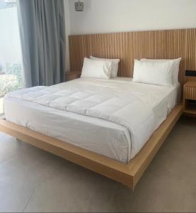 普拉迪斯亚罗斯Mykonos Drops的一张配有白色床单和枕头的大床
