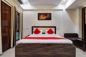勒克瑙Super OYO Natraj Inn Near SGPGI - Managed by Company的一间卧室配有一张带红色枕头的大床