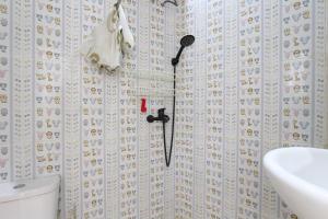 沙拉迪加Capital O 93939 Oikodomeo的带淋浴头和盥洗盆的浴室