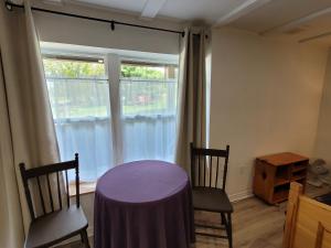 MiddletonEdelweiss Inn Nova Scotia的客房设有桌子、两把椅子和窗户。