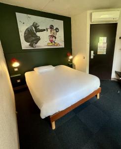 里摩日The Originals Access, Hôtel Limoges Nord的一间卧室,配有一张带猴子照片的床
