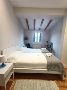 扎鲁亚斯Egona - Apartamento en el centro a 500mts de la playa Her2的白色的卧室设有一张大床和一个窗户