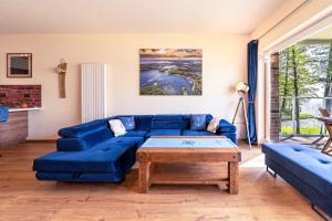 吉日茨科Nautica Resort的客厅配有蓝色的沙发和桌子