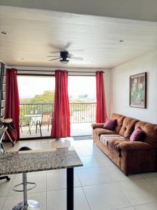 阿拉胡埃拉Maria´s Apartments的带沙发和红色窗帘的客厅