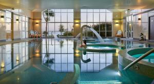 克洛纳基尔蒂因其多尼岛Spa酒店的一座大型游泳池,一个女人坐在喷泉里