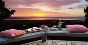 泰晤士格拉夫小屋酒店的一张桌子,上面放着食物和酒杯,日落