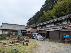 Seiyo古民家民宿カルフール的站在建筑物前面桌子上的女人