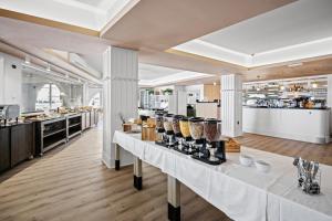 普拉海之酒店的一间设有白色桌子的餐厅,提供食物