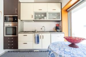 拉夫拉Oporto city and Beach apartment的厨房配有白色橱柜和桌上碗