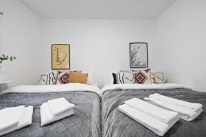 雷克雅未克Venture Vacation - Cozy and Central Apartment的客房内的两张床和白色毛巾