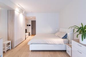 塔林Revalia Das Haus Studios的白色卧室配有白色的床和植物