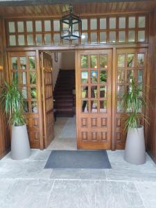 桑提亚纳德玛罗希达罗斯酒店的两株盆栽植物的建筑物入口