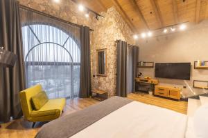 桑丹斯基Villa Sintica的一间卧室配有一张床、一台电视和一把椅子