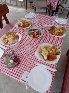 威尔帕扎Apartments Nino Skadar lake的一张红色和白色的桌子,上面有食物盘