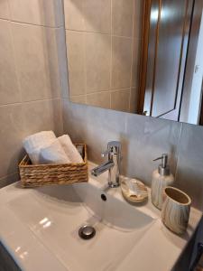 帕拉利亚潘塔利莫诺斯Veny House的浴室水槽,配有毛巾篮和镜子