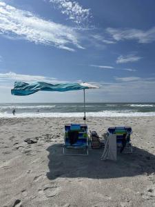 托普赛尔海滩Lil'TipSea on Topsail - Close to the sound and beach!的海滩上的两把椅子和一把遮阳伞