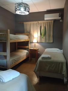 里奥塞瓦约斯HOTEL La Quebrada的配有仙人掌窗帘的客房内的2张双层床