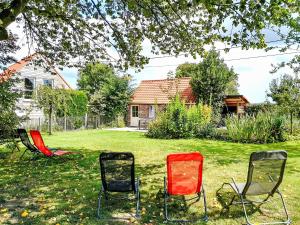 EllezellesHoliday Home Gîte L'Archipel by Interhome的坐在院子里的草地上的三把椅子