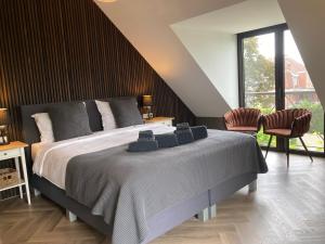 埃本埃迈尔Rue Haute by M&M 4 sterren bed en breakfast vlakbij Maastricht的一间卧室配有一张大床和两把椅子