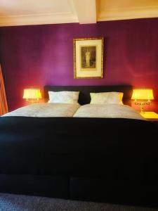 巴特施瓦尔巴赫MALEPARTUS的配有紫色墙壁和两盏灯的客房内的两张床