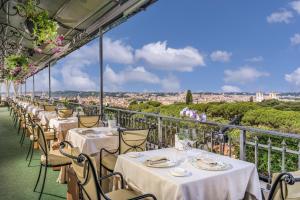 罗马Hotel Splendide Royal - The Leading Hotels of the World的餐厅阳台上的一排桌子