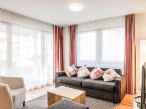 英格堡Apartment TITLIS Resort 2-Zimmer Wohnung 6 by Interhome的带沙发的客厅和部分窗户。