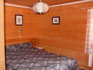 贝德雷托Apartment Verena by Interhome的卧室配有木墙内的一张床